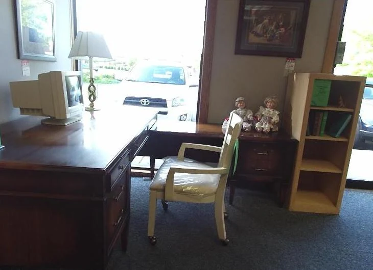 Input photo of an office corner with a wooden desk, a CRT monitor, a lamp, a chair and a bookcase